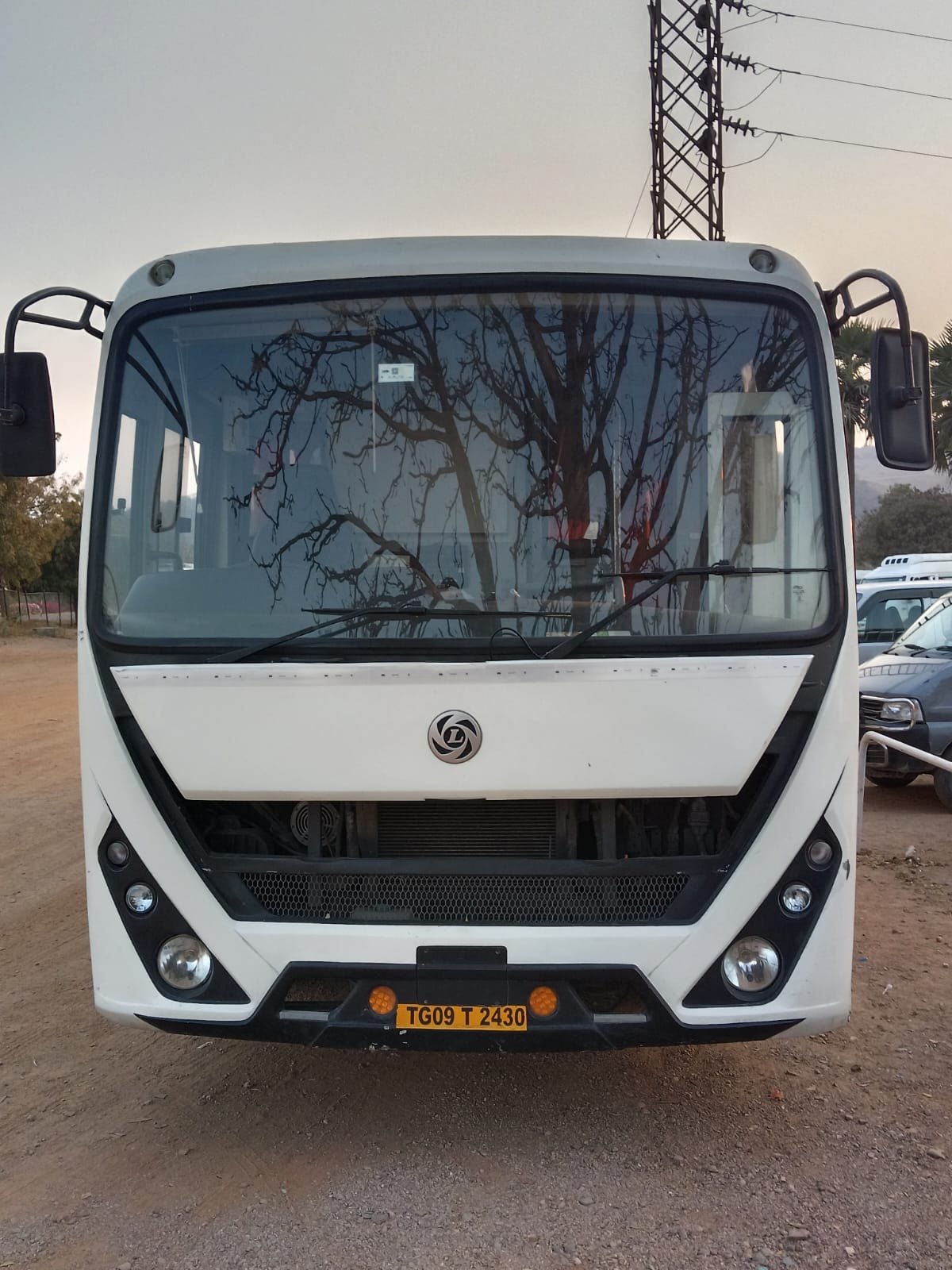 White JP Travels mini coach parked, front view